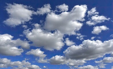 Fototapeta premium Fluffy white clouds scattered across a vibrant blue sky