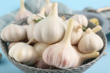 Obraz premium Bowl with fresh garlics on blue background, closeup