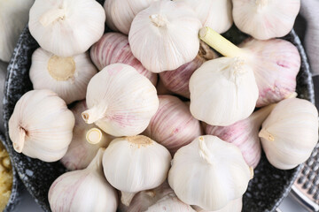 Many fresh garlics in bowl, closeup