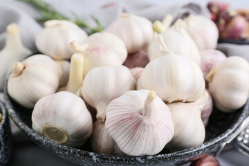 Bowl with fresh garlics on grey background, closeup