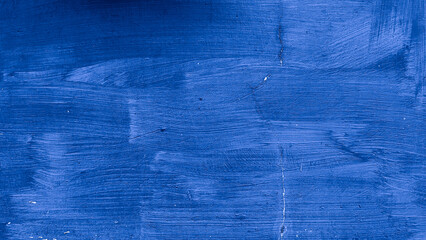 Close-up of blue painted wall with visible brush strokes, cracks, and subtle imperfections on the...