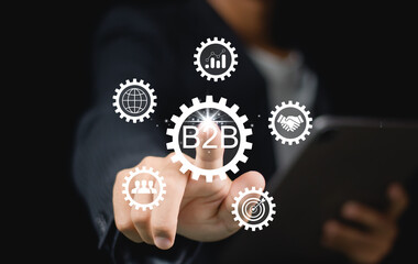Business to business (B2B) market concept. B2B transactions, exchanging of goods and services between organizations. Businessman showing screen for B2B management by using digital platforms.