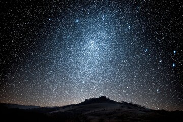 Starry night sky over dark hills