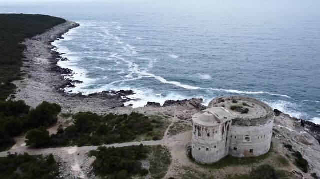 Aerial view of Mamula Fortress and rocky coast near Herceg Novi, Montenegro, with waves crashing below. g.