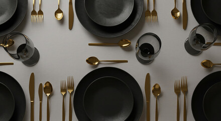 Elegant dinner table setting with black plates and gold cutlery
