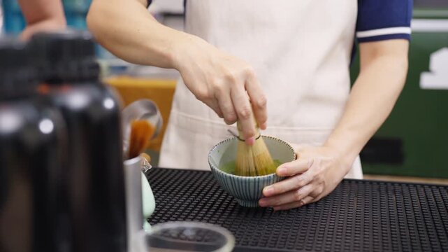 Small business entrepreneur coffee shop cafe restaurant. Asian woman barista preparing matcha green tea drink on bar counter. Female waitress working part time job serving beverage to customer.