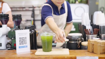 Small business entrepreneur coffee shop cafe accepts payment via QR code. Barista preparing iced green tea on bar counter. Non binary person working part time job serving beverage drink to customer. - Powered by Adobe