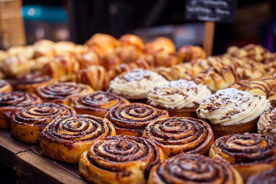 Delicious cinnamon rolls and pastries on display at a bakery - Powered by Adobe