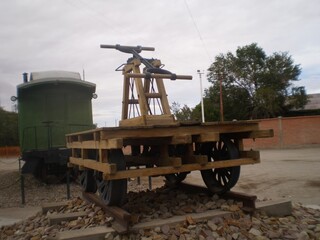 A wooden cart with a metal handle is sitting on a train track