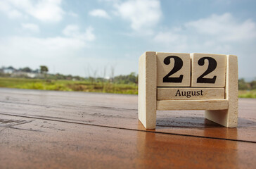 Wooden cube calendar for 22nd August place on a table in a sunny day background