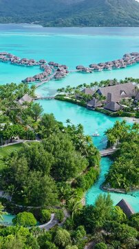 Bora Bora, French Polynesia. Vertical Drone Shot of Luxury Resort With Bungalows Over Water, Lagoon and Island
