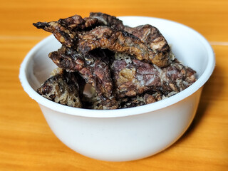 Fried beef lung with flour, has a delicious and delicious taste, served in a white bowl on a wooden table.