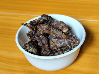 Fried beef lung with flour, has a delicious and delicious taste, served in a white bowl on a wooden table.