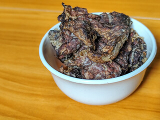 Fried beef lung with flour, has a delicious and delicious taste, served in a white bowl on a wooden table.