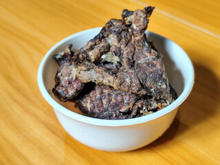 Fried beef lung with flour, has a delicious and delicious taste, served in a white bowl on a wooden table.