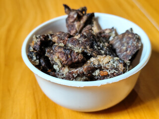 Fried beef lung with flour, has a delicious and delicious taste, served in a white bowl on a wooden table.