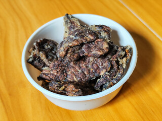 Fried beef lung with flour, has a delicious and delicious taste, served in a white bowl on a wooden table.