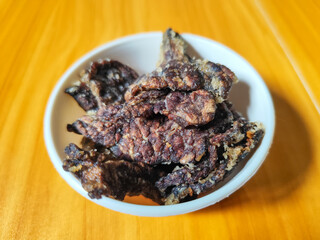 Fried beef lung with flour, has a delicious and delicious taste, served in a white bowl on a wooden table.