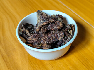Fried beef lung with flour, has a delicious and delicious taste, served in a white bowl on a wooden table.