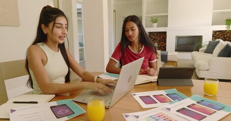 After opening laptop, Diverse women exchanging color palettes at dining table for design planning - Powered by Adobe