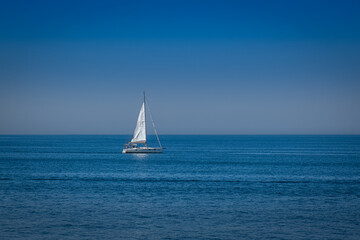 Fototapeta premium open sea. a white sailboat is sailing.