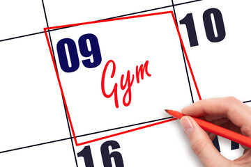 9th day of the month. Hand writing Gym reminder and drawing red frame on calendar with red pen on...