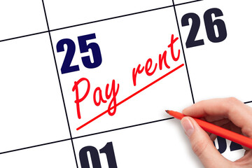 25th day of the month.  Hand writing Pay rent reminder and drawing a line on calendar with red pen...