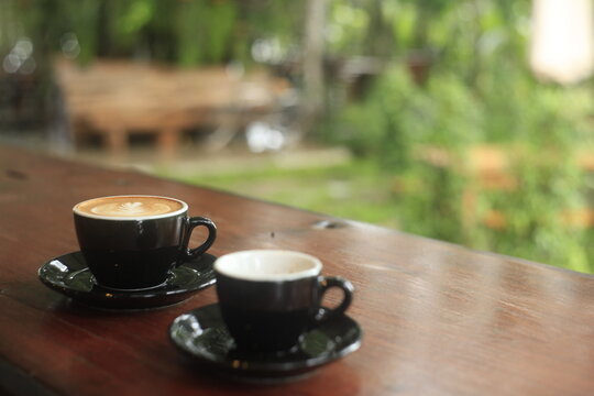 Two cups of hot coffee lined up in a natural setting