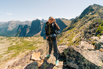 russia, ergaki - 4 august 2025 Hiker girl in a cap and with a backpack in the mountains