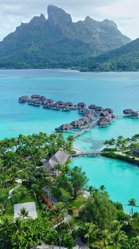 Bora Bora, French Polynesia. Vertical Drone Shot of Luxury Resort With View on Main Island, Overwater Bungalows and Lagoon