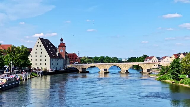 Steinerne Brucke bridge from Eiserne Brucke in Regensburg, spanning the Danube River, medium slow motion establishing