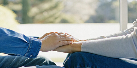 Abstract background. Close-up of two people holding hands in the concept of caring and supporting each other