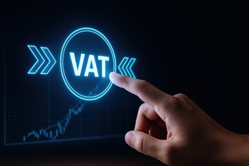 Tax impact trade. Hand pointing at a digital VAT icon on a screen with a financial graph in the background.