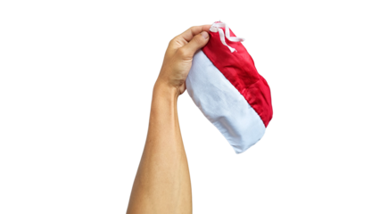 Photo of a hand holding the red and white Indonesian flag against a clean white background, highlighting the fabric texture and vibrant colors as a symbol of pride and patriotism.