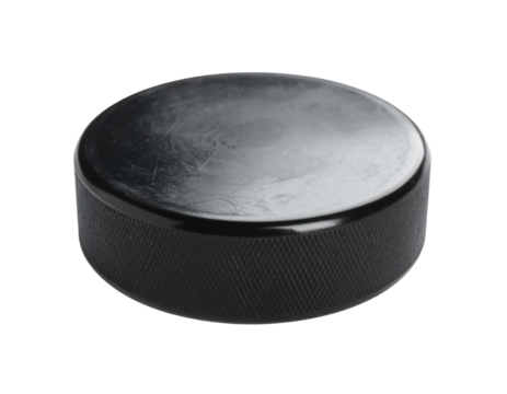 A black hockey puck with a smooth surface and textured edges, commonly used in ice hockey games.