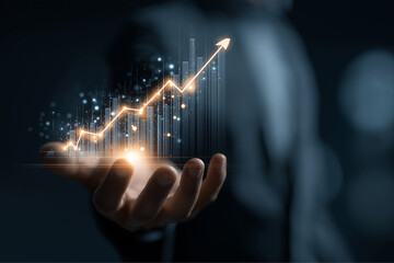 Hand holding glowing graph with upward trend and sparkling light effects