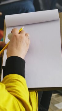Lady uses sketching technique drawing on sheet in studio. Artist holds pencil and creates outline of figure practicing skills in special art lesson