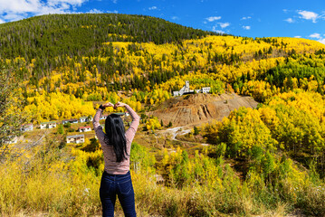 A tourist enjoys autumn at the Abandoned Gilman Mine, Colorado Fall