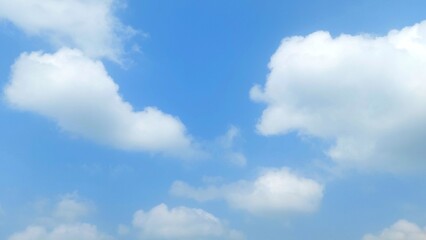 Clear blue sky with soft white clouds. Bright summer sky background. Soft white clouds float in the clear blue sky. Clear blue sky, bright spring, soft sky gradient, wallpaper landscape, aerial view.