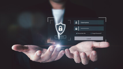 A businessman in a suit presents a holographic login interface with a security shield, symbolizing cybersecurity, user authentication, and data protection technology.
