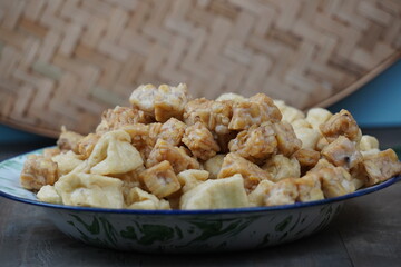 A plate of fried tofu and tempeh on a wooden table.