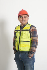 Asian construction worker wearing safety vest and helmet, standing confidently, showing professionalism. Isolated image on white background