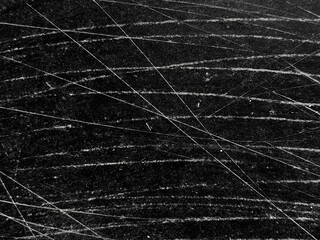 Black and white grunge scratch and dust texture backdrop or overlay. White scratches and dust on black background with copy space.