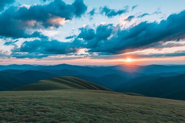 A vibrant sunset casts a warm glow over rolling hills and distant mountain ranges, evoking a sense of peaceful solitude and natural beauty in a sweeping landscape.