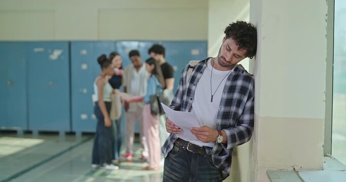 Indian sad young adult gen z man feel low look upset hold result paper report card fail in study exam at campus place alone lost teen man boy crying wipe tears suffer fear social bully bad hostel life