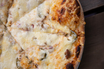Close-Up View of a Cheesy Pizza Slice on a Wooden Table