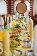 Long banquet table set with various dishes in a traditional dining hall