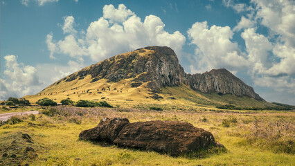 Southwest face of the Rano Raraku volcano dotted with abandoned moai statues, Rapa Nui (Easter Island), Chile. It was the quarry of all moai statues. In the foreground, an abandoned moai.