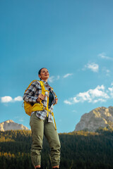 Female hiker standing with the blue sky behind her