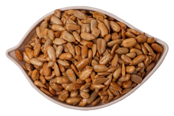 Peeled sunflower seeds in teriyaki sauce in a leaf-shaped plate isolated on white background, top view